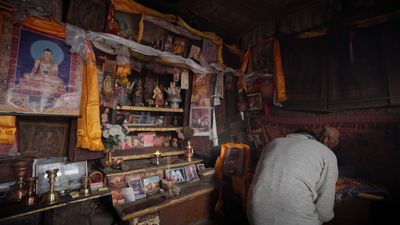 a man standing in front of a shelf filled with pictures