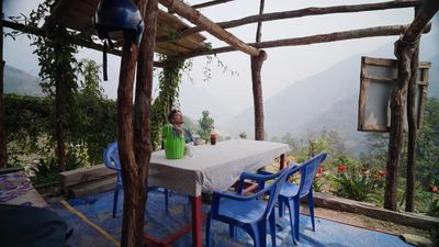 a woman sitting at a table in a covered area