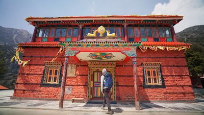 a person standing in front of a red building