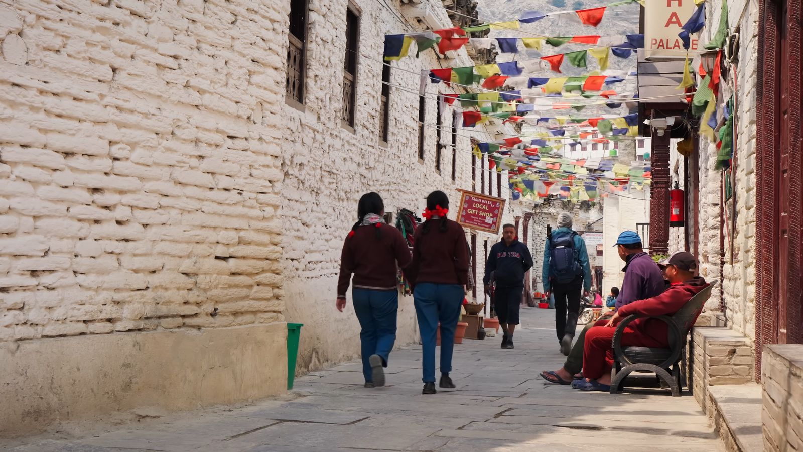 a group of people walking down a street next to a building