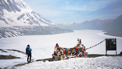 a person standing next to a mountain covered in snow