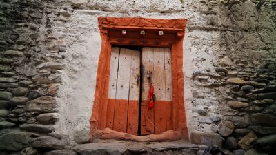 a red and white door in a stone building