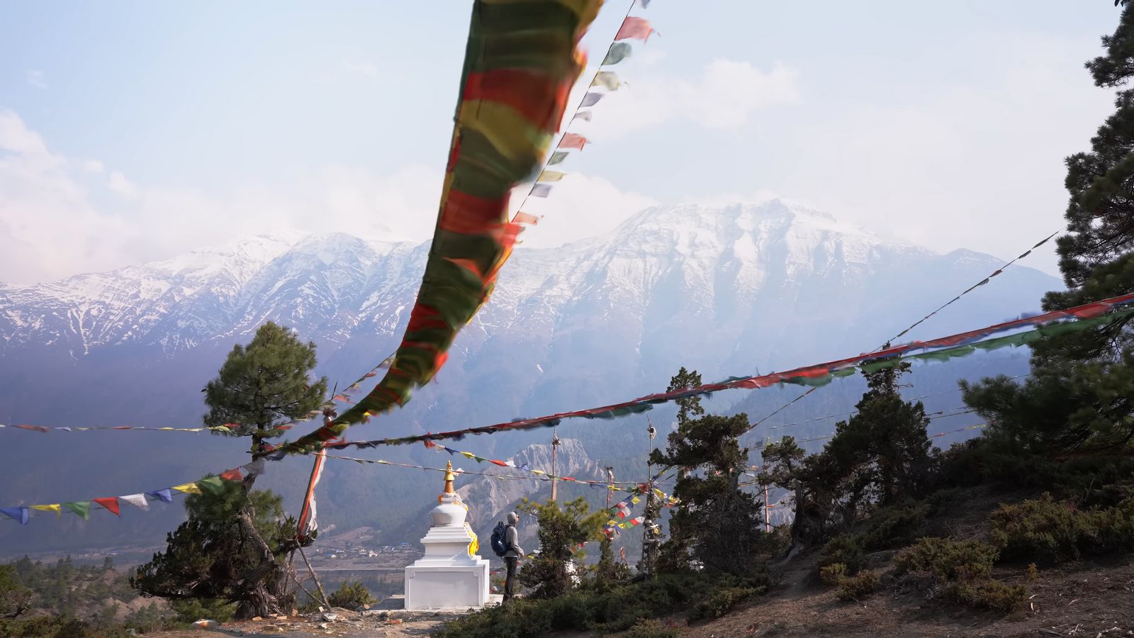 a view of a mountain range with prayer flags in the foreground