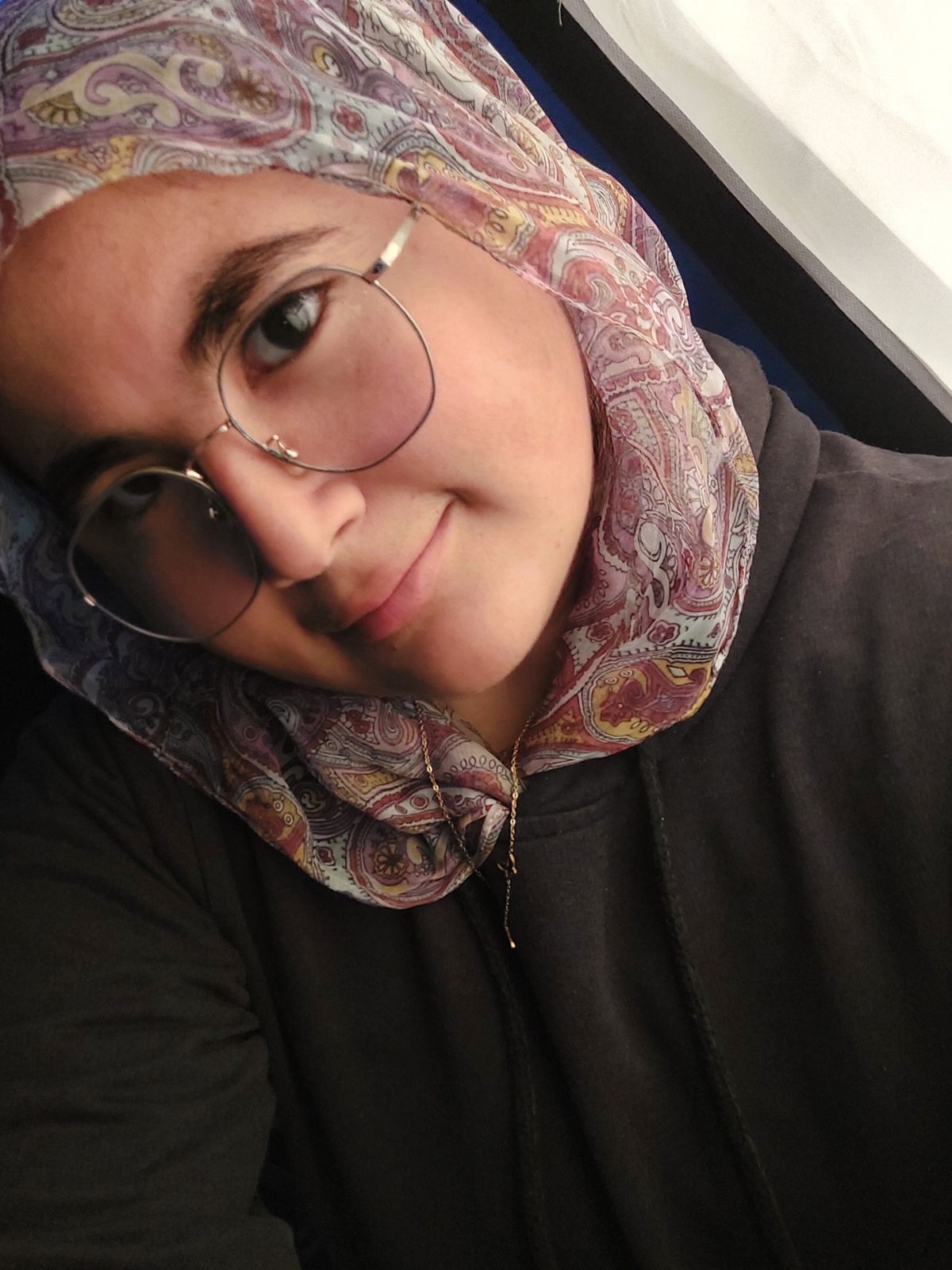 a woman wearing a headscarf and glasses