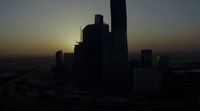 the sun is setting over a city with tall buildings