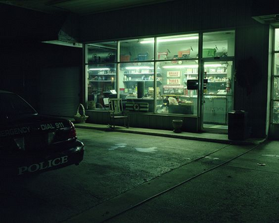 a police car parked in front of a store at night