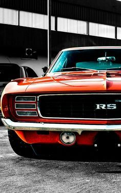 an orange muscle car parked in a parking lot