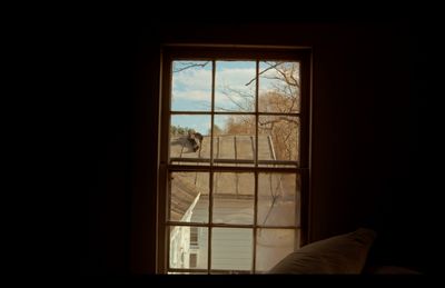 a window with a view of a roof and trees