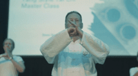 a man standing in front of a projector screen