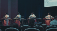 a group of people sitting on top of a stage