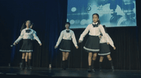 a group of young girls standing on top of a stage