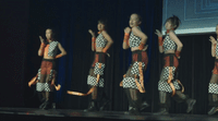 a group of women standing on top of a stage