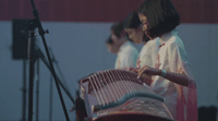 a woman playing a musical instrument in front of a microphone