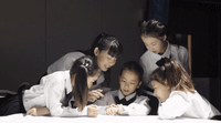 a group of young girls sitting around a table