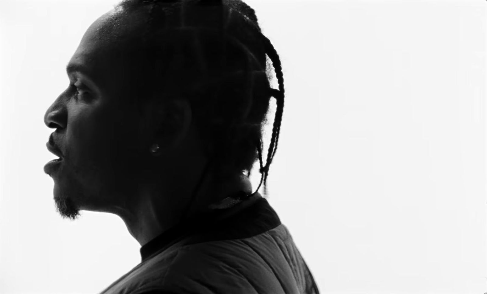 a black and white photo of a man with dreadlocks