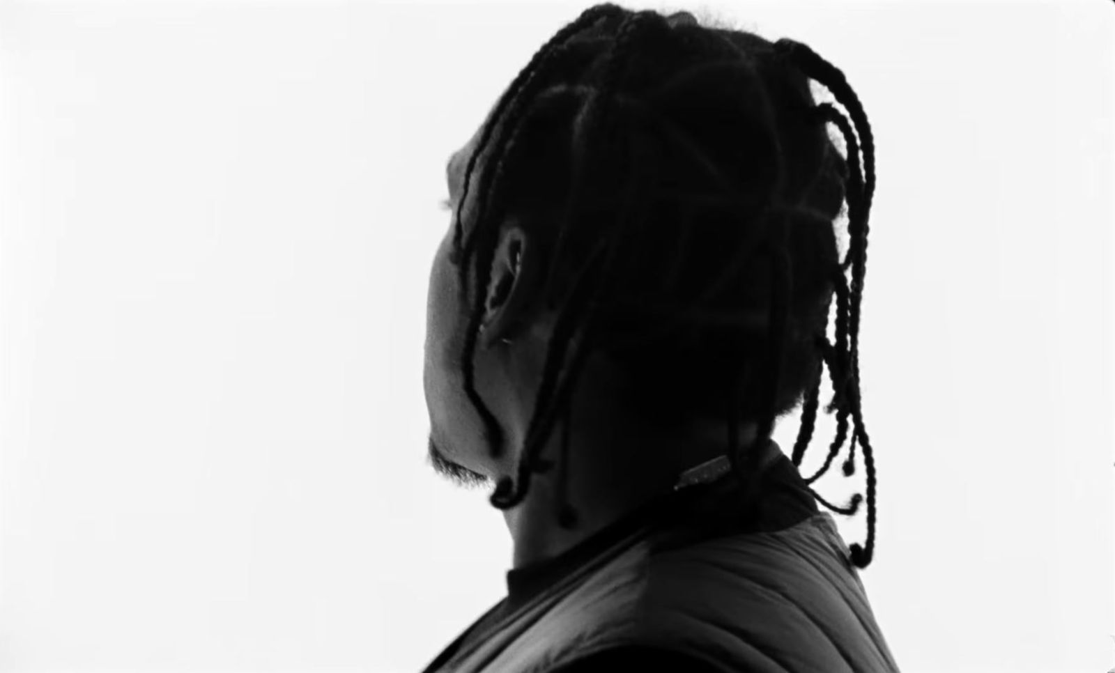 a black and white photo of a man with dreadlocks