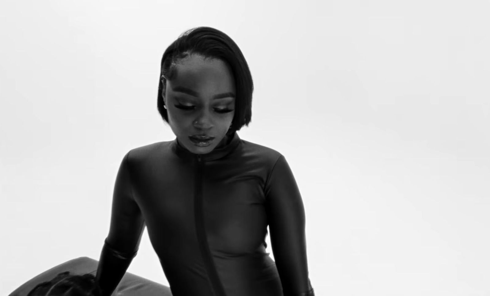 a woman in a wet suit sitting on the ground