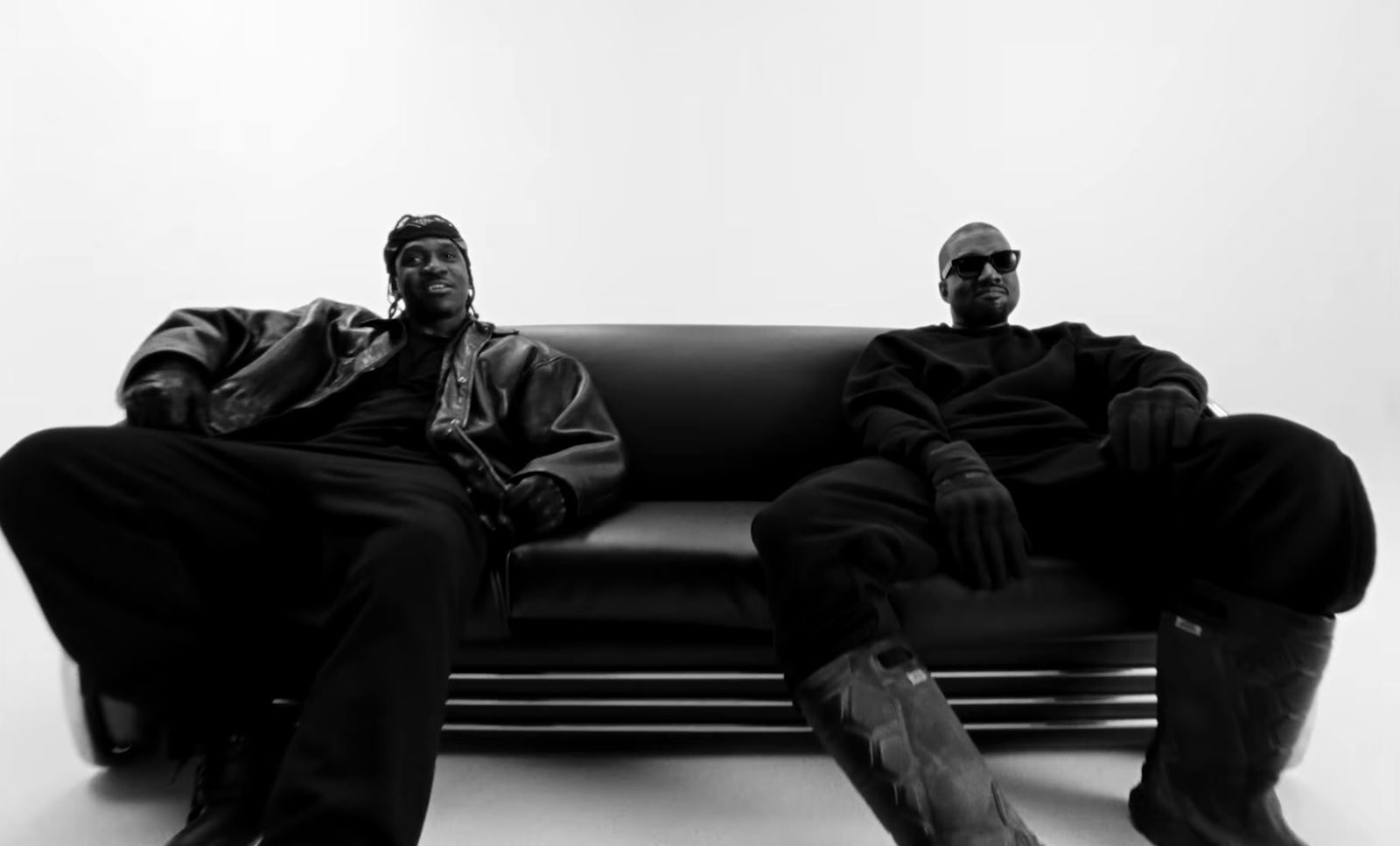 a couple of men sitting on top of a black couch