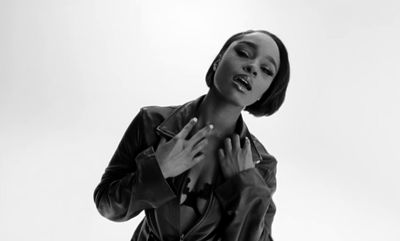 a black and white photo of a woman in a leather jacket