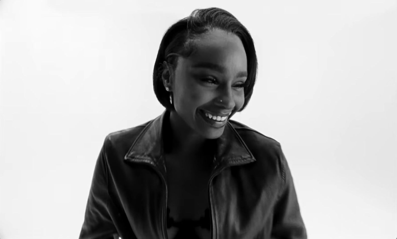 a woman in a black leather jacket smiling