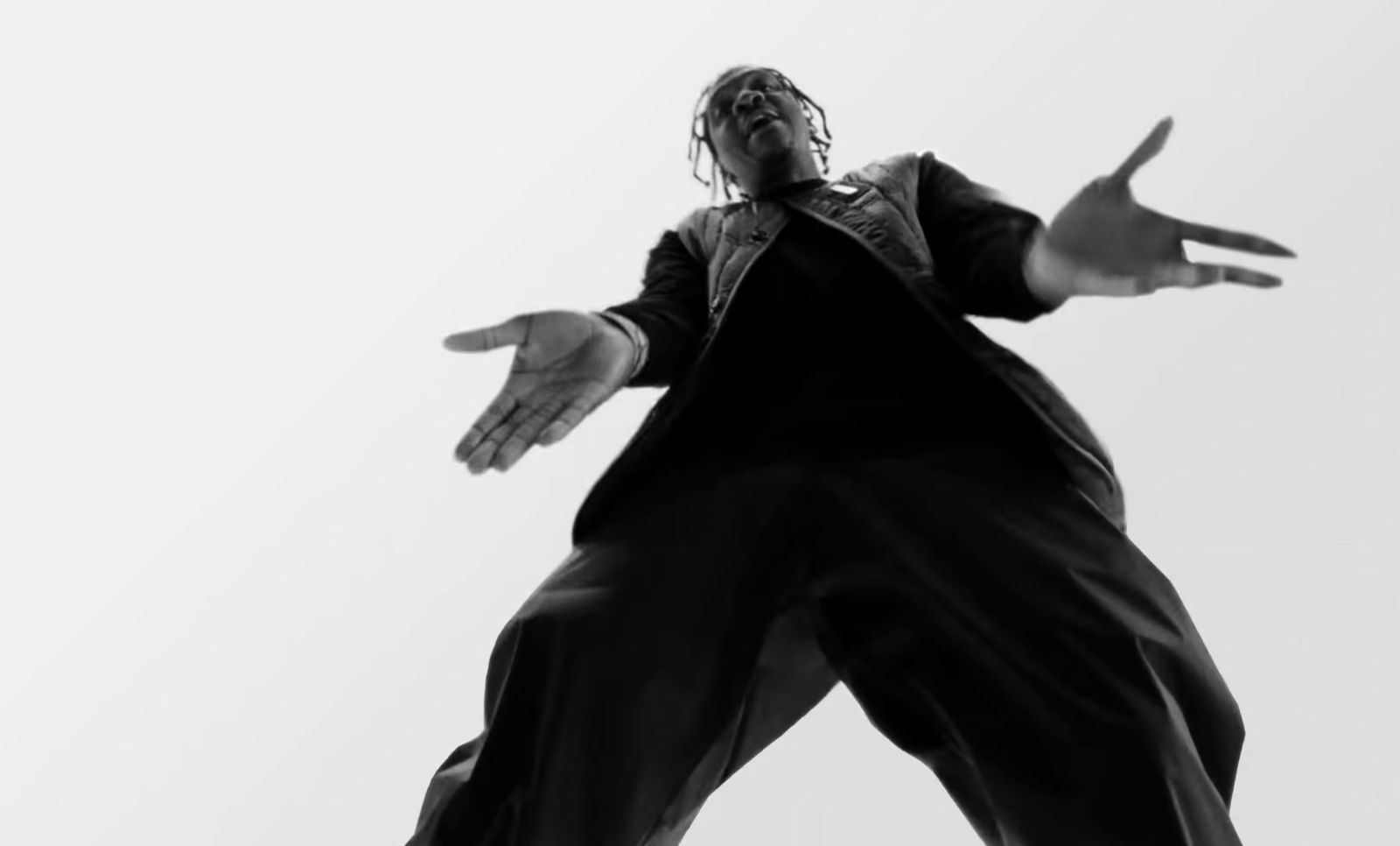 a black and white photo of a man doing a trick on a skateboard