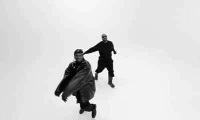 a couple of men standing on top of a snow covered ground