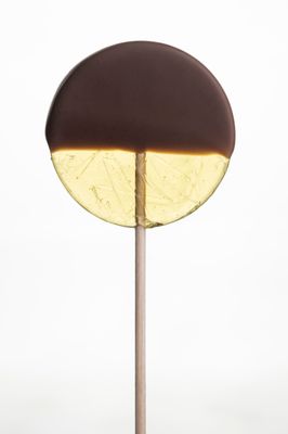 a brown and yellow object sitting on top of a wooden stick