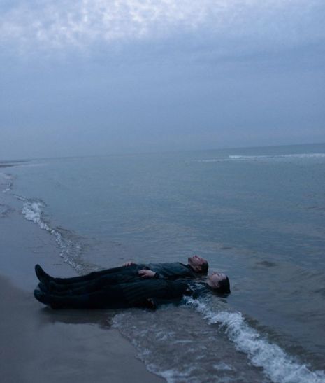 a man laying on top of a body of water