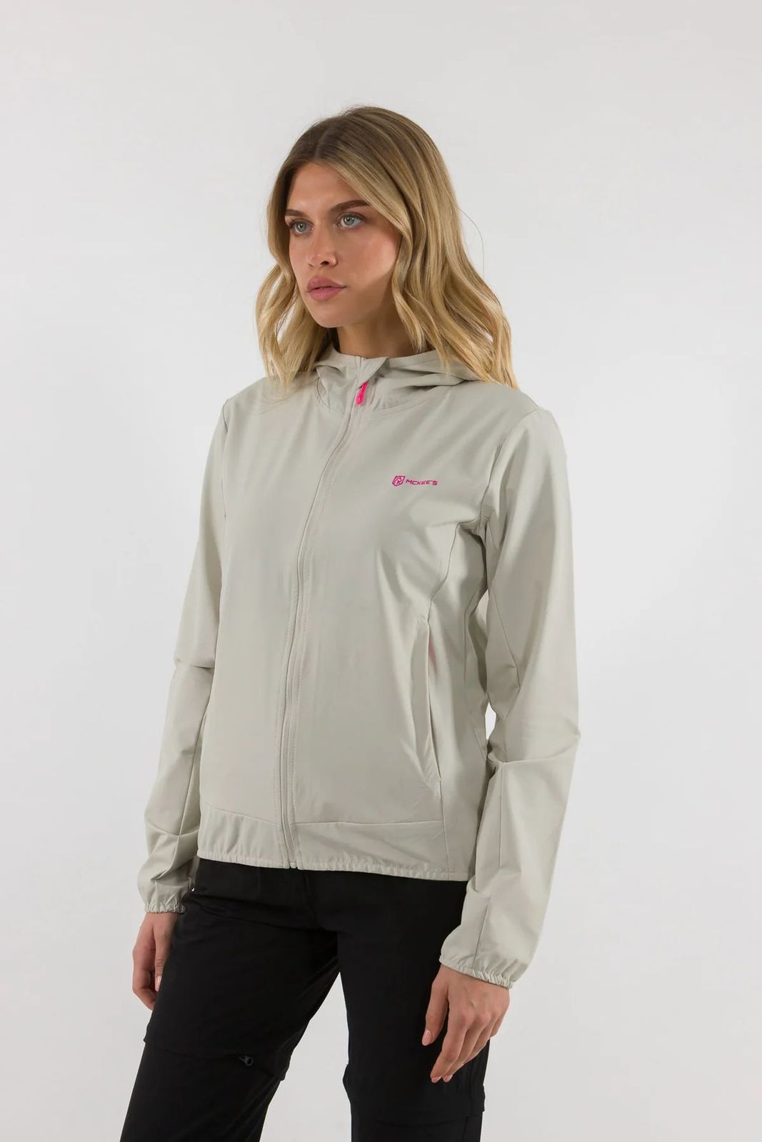 a woman wearing a light gray jacket and black pants