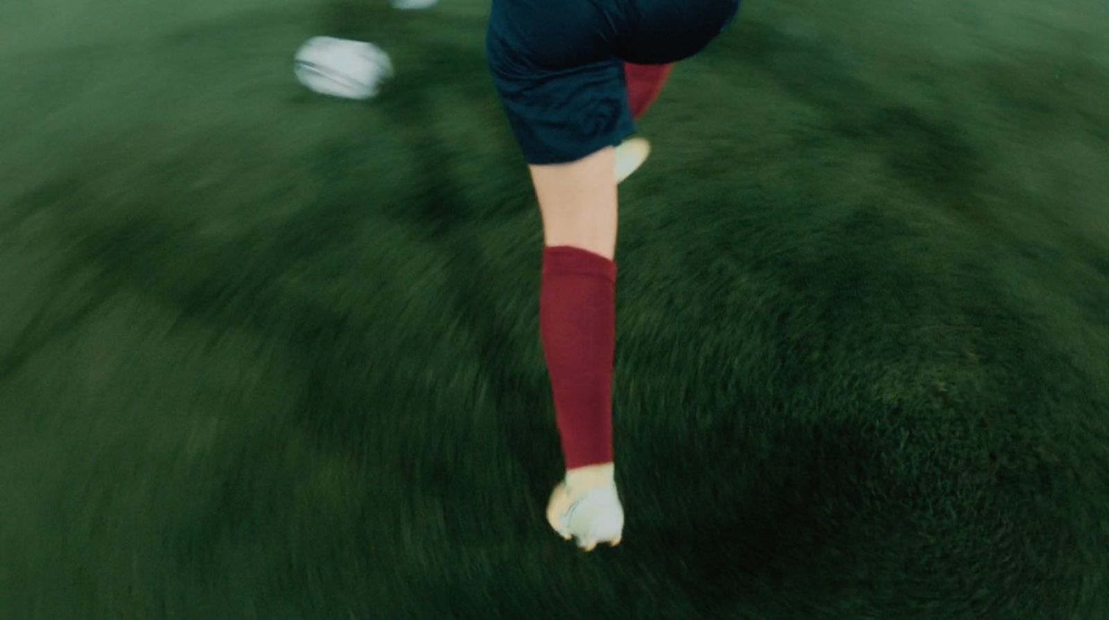 a woman kicking a soccer ball on a field