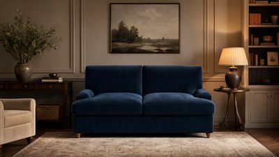a blue couch sitting in a living room next to a lamp