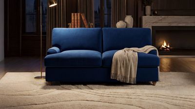 a blue couch sitting in a living room next to a fire place