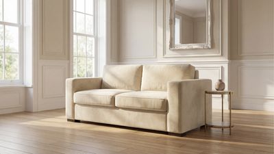 a white couch sitting in a living room next to a window
