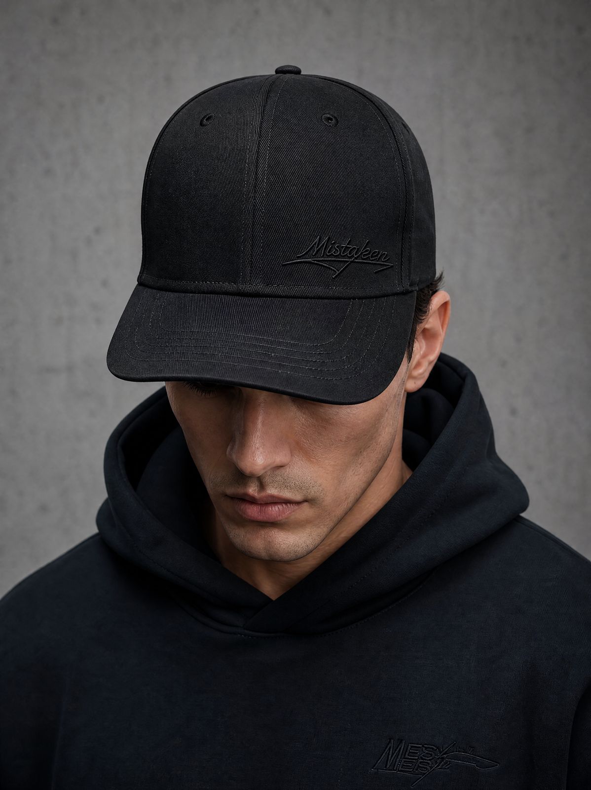 a man wearing a black hat and a black sweatshirt