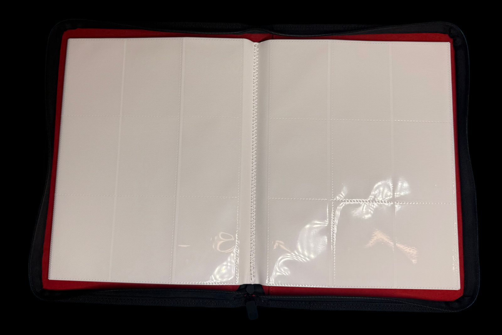 an open notebook with a red cover and a white sheet of paper