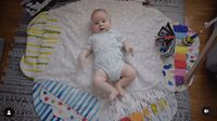 a baby laying on top of a white blanket