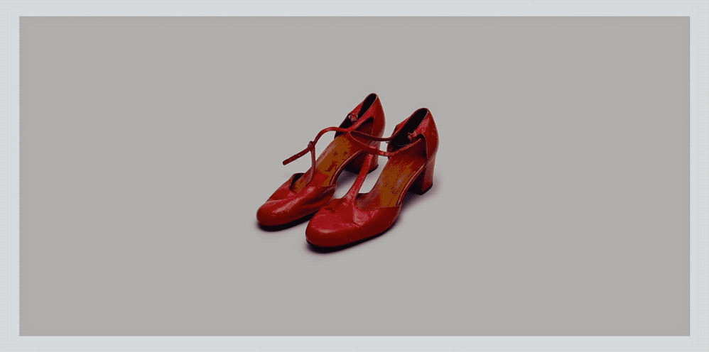 a pair of red shoes sitting on top of a white floor