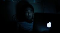 a man sitting in the dark with a laptop