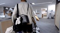 a man carrying a black bag in a room