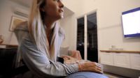 a woman sitting on a chair in front of a tv