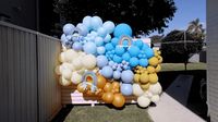 a bunch of balloons that are on a fence