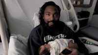 a man holding a baby in a hospital bed