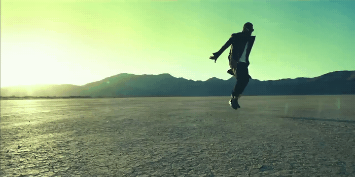 a person jumping in the air in the middle of a desert