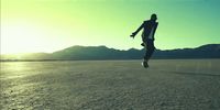 a person jumping in the air in the middle of a desert
