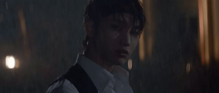 a man in a white shirt and tie standing in the rain