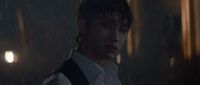 a man in a white shirt and tie standing in the rain