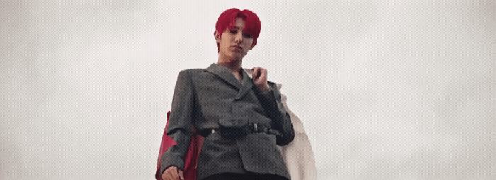 a woman with red hair and a gray jacket