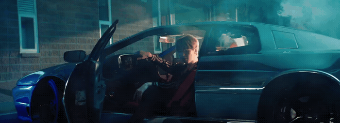 a woman sitting in the back of a blue car