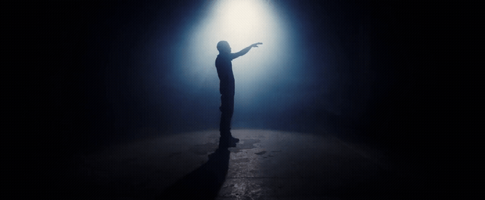 a person standing in the dark holding a light