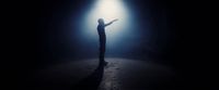 a person standing in the dark holding a light